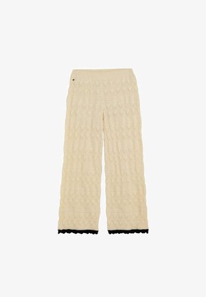 Cream knit wide-leg pants with zigzag pattern and black scalloped trim at the hem, featuring a small round detail near the waistband.