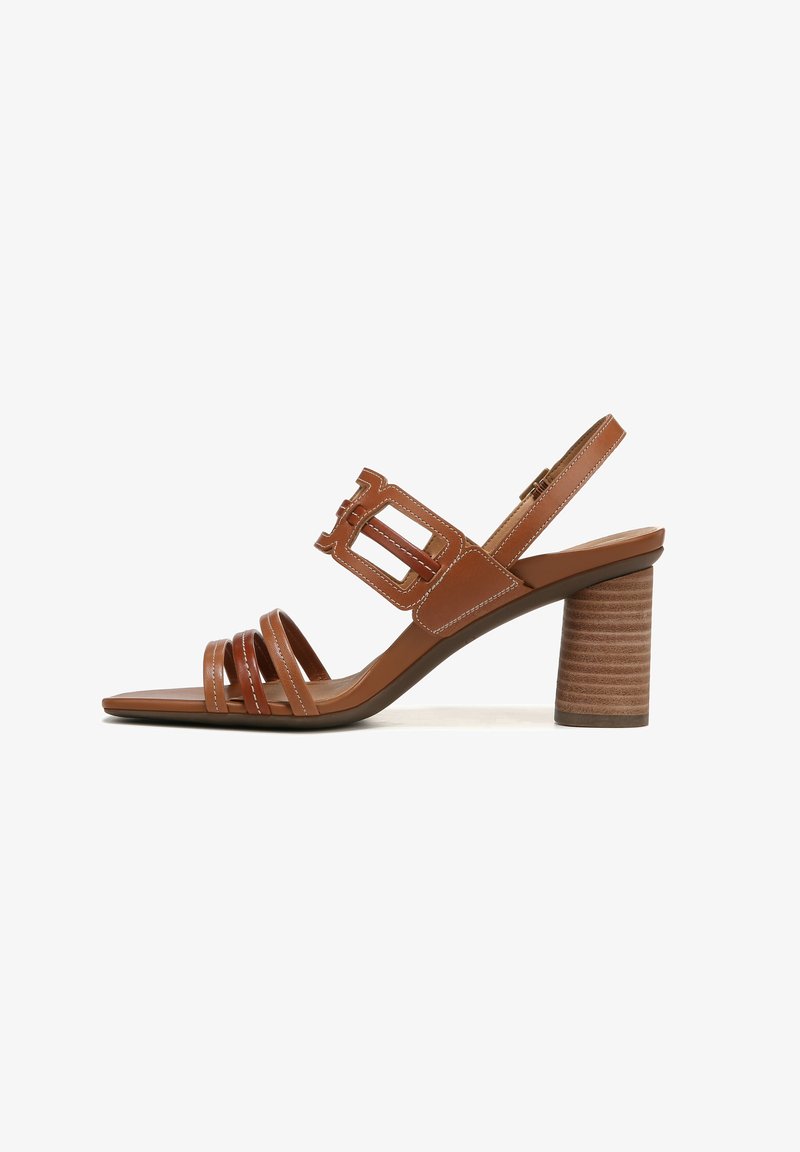 Sandale à talon en cuir marron avec trois lanières frontales, une large lanière à boucle sur le cou-de-pied, une lanière à la cheville, et un talon bloc empilé sur fond blanc.
