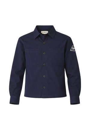 Camicia blu navy a maniche lunghe con bottoni, colletto, due tasche sul petto e un logo a toppa bianco sulla parte superiore della manica sinistra.