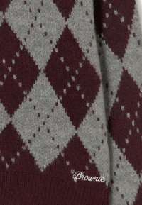 Tejido de punto con patrón de diamantes argyle en color burdeos y gris, con texto bordado en blanco "Brownie" en la parte inferior derecha.