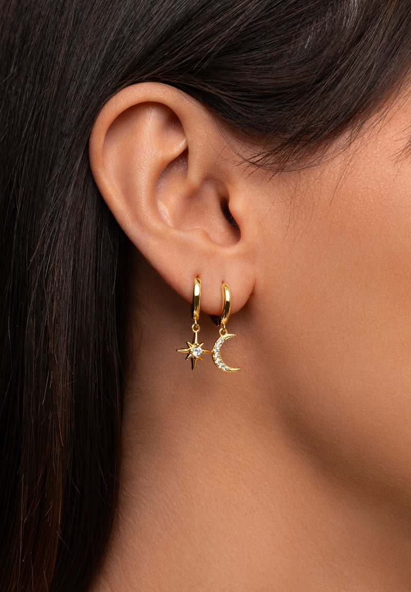 Boucles d'oreilles en or en forme de créoles, ornées d'un pendentif en étoile avec une pierre précieuse transparente et d'un pendentif en croissant de lune décoré de strass.
