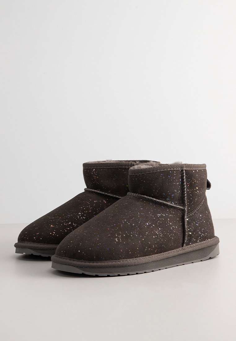Een paar donkerbruine enkellaarsjes met multikleurtje spikkels, luxe voering en platte rubberen zolen op een neutrale achtergrond.