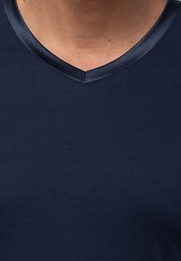 Marineblaues V-Ausschnitt-T-Shirt aus weicher Baumwolle, mit einem kontrastierenden satinbesetzten Saum am Ausschnitt und einer glatten Textur.