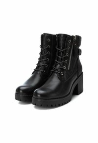 Botas de tobillo de cuero negro con un patrón de acolchado texturizado, cordones en el frente, cremallera lateral y un tacón grueso. Cuenta con un suave collar de piel.