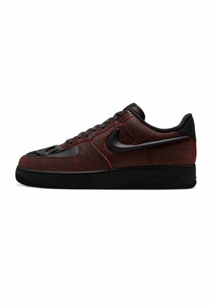 Zapatilla Nike Air Force 1 de perfil bajo en negro y rojo oscuro con parte superior texturizada, suela negra, cordones y logotipo swoosh en el lateral.