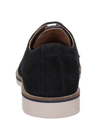 Chaussure en suede noir avec un talon arrondi, intérieur en cuir tan et semelle en caoutchouc présentant une texture tissée et des détails de coutures subtils.