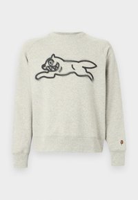 Ανοιχτό γκρι φούτερ με μαύρο σχέδιο μιας γάτας που πηδάει μπροστά και ένα μικρό μπαλώμα παγωτού στο αριστερό μανίκι.