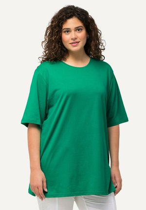 Grünes T-Shirt mit kurzen Ärmeln aus weicher Baumwolle. Hat einen runden Ausschnitt und einen lockeren Schnitt, der über die Taille hinausgeht. Einfaches Design.