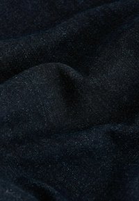 Sötét farmer anyag, amelynek enyhe fényessége van, sima textúrával és kis színváltozásokkal. Nincs látható minta vagy hardver.
