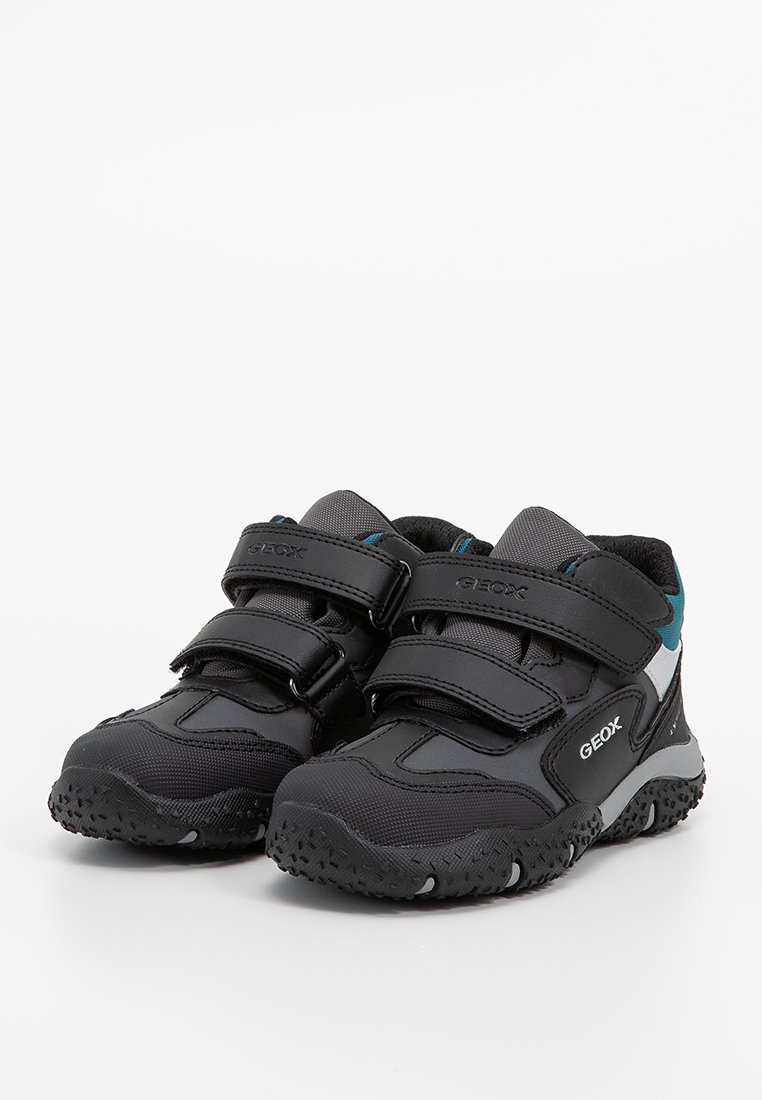 Schwarze Sportschuhe mit zwei Klettverschlüssen, atmungsaktiven Mesh-Einsätzen, Gummisohle mit rutschfester Struktur und kontrastierenden Tealtönen.