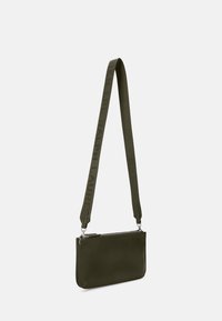 Bolso bandolera de cuero verde oliva con una correa texturizada que presenta una marca en relieve. Cierre con cremallera y forma rectangular elegante.