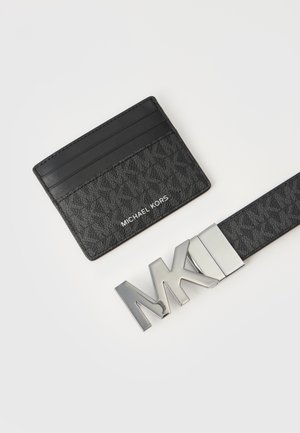 Fekete Michael Kors kártyatartó több rekesszel és hozzá illő fekete öv, amelyen nagy ezüst MK csat található.
