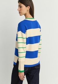 Gestreepte trui in blauw, beige en groen; geribbelde manchetten; ronde hals; relaxed fit; zijsplitten aan de onderkant voor meer bewegingsvrijheid.