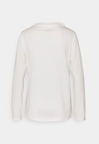 Långärmad skjorta i mjuk vit bomull, med rund halsringning och rak fåll, utan synliga sömmar eller mönster.