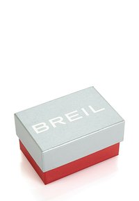 Stříbrná obdélníková dárková krabička s červeným podstavcem, na víku s bílým reliéfním textem "BREIL", hladká textura a čistý design.