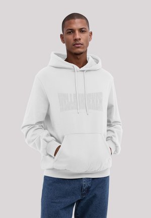 Weißer Kapuzenpullover mit einer Fronttasche und Kordeln, versehen mit einem dezenten Textdesign. Getragen mit blauen Jeans. Glatte Textur.