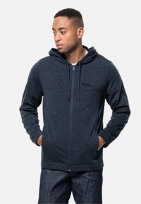 Felpa con cappuccio zip blu navy realizzata in morbido tessuto, dotata di tasche a marsupio e logo sul petto. Presenta una vestibilità comoda e coulisse regolabili.