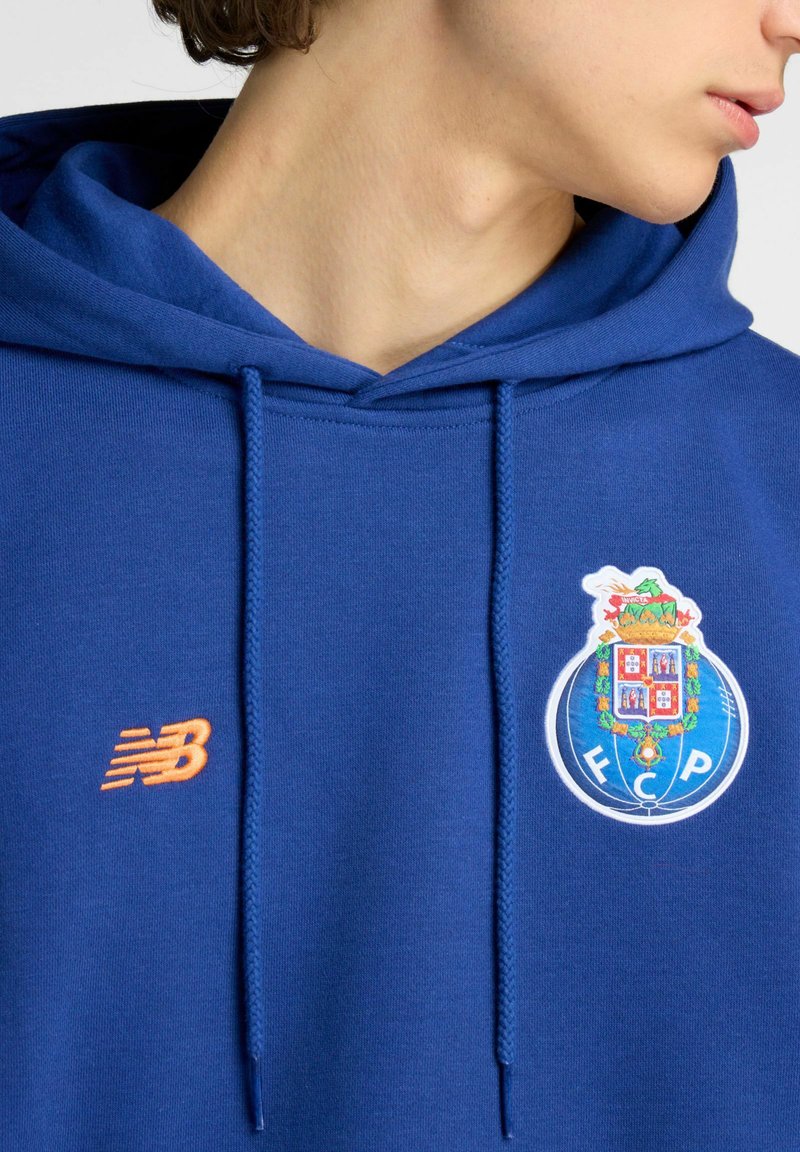 Blauer Baumwoll-Hoodie mit einem weißen, bestickten FC Porto-Logo und einem orangefarbenen New Balance-Logo auf der Brust. Verstellbare Kapuze mit Kordelzug.