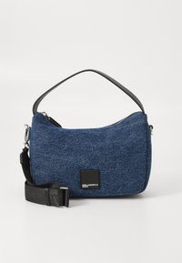 Denim crossbody bag with a dark blue textured finish, black adjustable strap, and zip closure. Features logo patch on the front.