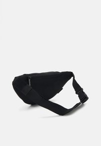 Sac banane noir en tissu texturé, avec fermeture éclaire, sangle réglable et forme triangulaire épurée.