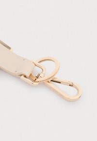 Beige leather strap with gold-tone metal hardware, featuring a double ring and a clasp for secure attachment.