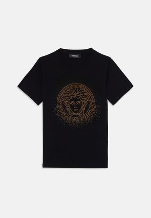 Sort bomulds-T-shirt med et guld Medusa-grafik med et struktureret, prikket mønster og græske nøgle-detaljer omkring billedet. Korte ærmer.