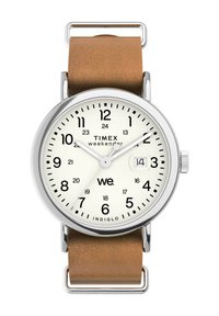 Montre Timex Weekender avec un cadran blanc, des chiffres noirs, un boîtier en argent et un bracelet en cuir marron. Elle dispose d'un affichage de date et d'un rétroéclairage Indiglo.