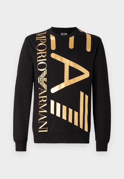 Sweatshirt noir en coton avec un grand logo doré et des éléments graphiques, comprenant des rayures et un logo d'aigle, avec des poignets côtelés.