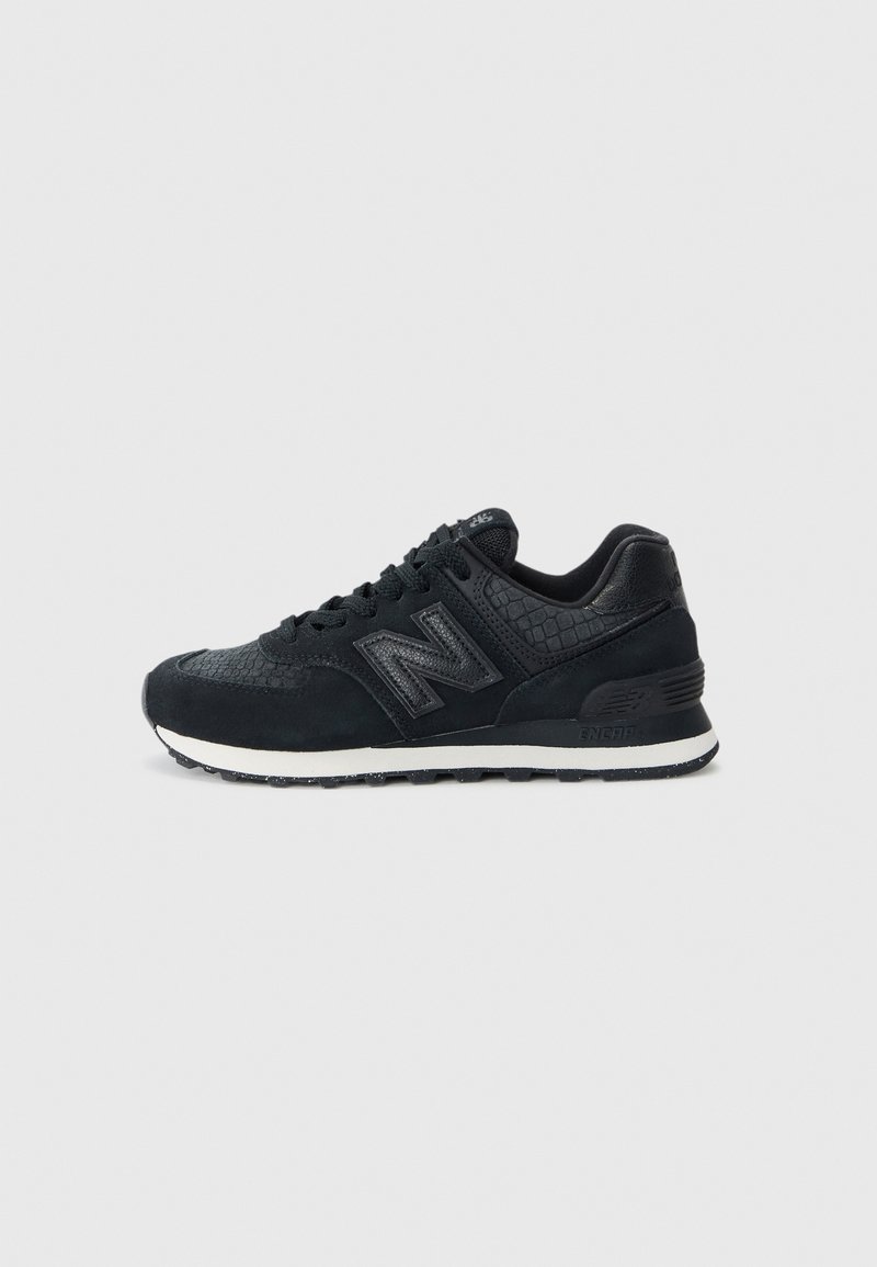 Basket New Balance noire avec dessus texturé, semelle intermédiaire blanche, semelle extérieure noire et fermeture à lacets, vue de profil sur fond gris clair.