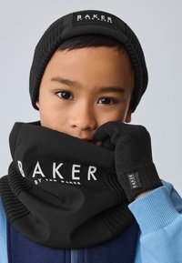 Mustast kudumist müts ja kaela soojendaja logomärgiga, tekstureeritud kindad ja sinised varrukad. Kõik aksessuaarid on valmistatud pehmest, elastset materjalist.