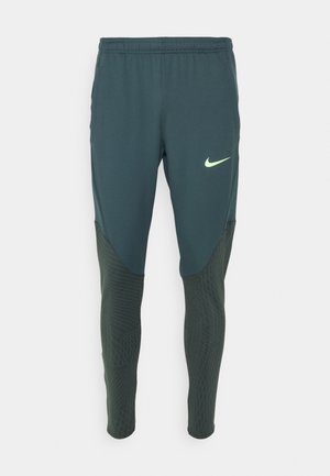 Ciemnozielone spodnie sportowe Nike z elastycznym pasem, otworami na kciuki i jasnozielonym logo na górnej części uda.
