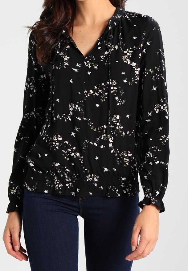 Blusa nera con motivo floreale, con scollatura arricciata, maniche lunghe e vita elasticizzata. Tessuto leggero con una texture liscia.