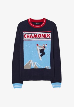 Maglione blu navy con grafica "Chamonix" che rappresenta una figura da snowboard, montagne e uno sfondo blu. Accenti in rosso e azzurro.