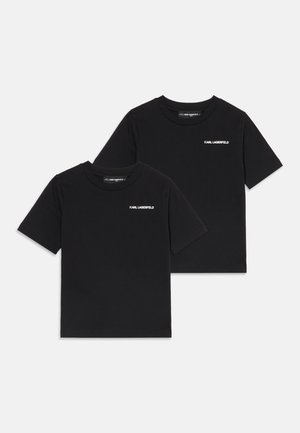 Dwa czarne t-shirty z krótkim rękawem z nadrukiem "Karl Lagerfeld" w białym kolorze na lewej piersi, ułożone płasko i nachodzące na siebie na białym tle.