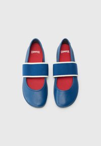 Modré kožené boty s kulatou špičkou, s širokým modrým elastickým páskem přes střed chodidla a kontrastní červenou stélkou.