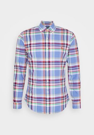 Koszula na długi rękaw z zapięciem na guziki, w niebieską kratę z czerwonymi, zielonymi i białymi akcentami. Wykonana z bawełny, z klasycznym kołnierzykiem.
