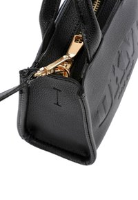 Geantă de mână din piele neagră cu logo embossat, fermoar auriu și finisaj texturat. Formă compactă cu mânere superioare și accente laterale.