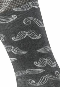 Graue Socken mit einem wiederholten weißen Schnurrbartmuster, einer glatten Textur und einem gerippten Bündchen, die ein verspieltes und einzigartiges Design bieten.