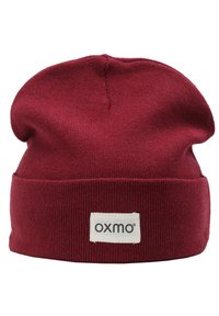 Red knit beanie hat with a folded cuff, made of soft fabric. Features a rectangular patch with the brand name "oxmo" in black text.