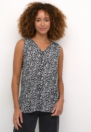 Blouse sans manches noire avec un col en V, ornée d'un motif floral blanc, en tissu léger et avec une texture plissée.
