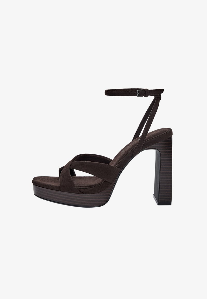 Brown suede platform sandals featuring a thick block heel, crossed straps across the toe, and an ankle strap with a metal buckle.