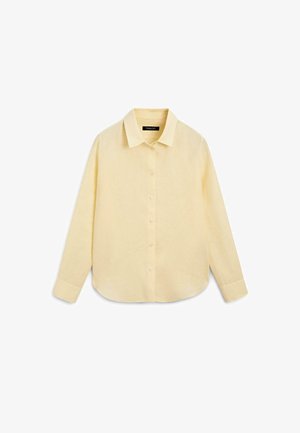 Bladożółta koszula z długim rękawem, zapinana na guziki, z szpiczastym kołnierzykiem i mankietami zapinanymi na pojedynczy guzik, pokazana rozłożona na białym tle.
