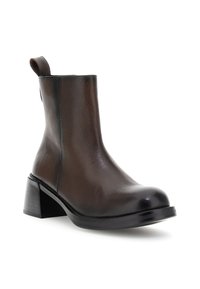 Bota de tobillo de cuero marrón oscuro con tacón cuadrado y tirador en la parte trasera, sobre un fondo blanco.