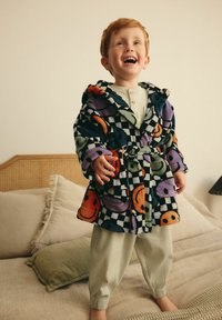 Fleece-Bademantel mit buntem Smiley-Gesichtsmuster, kariertem Design, übergroßer Kapuze, in der Taille gebunden, kombiniert mit leichten gerippten Hosen.