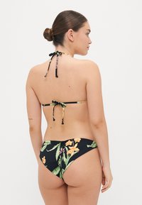 Crna bikini s cvjetnim uzorkom, s podesivim vezicama na vratu i leđima, glatkom teksturom i šarenim naglašama listova i cvjetova.