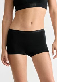 Schwarze Baumwollboxershorts mit einem glatten Bund, die ein schlichtes Design und minimale Nähte aufweisen. Eignet sich für den täglichen Gebrauch.
