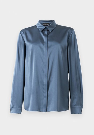 Camisa de satén azul de manga larga con botones ocultos, cuello puntiagudo y puños abotonados, exhibida sobre un fondo blanco.