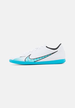 Chaussure de football en salle Nike Mercurial blanche avec semelle bleu vif et swoosh à motif sur le côté.