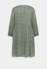 Zielona sukienka w wzory z długimi rękawami, okrągłym dekoltem, warstwowym fasonem i lekkim materiałem z rozproszonym czarnym printem.