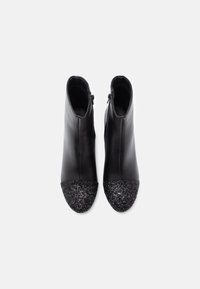 Μαύρες δερμάτινες μποτάκια έως τον αστράγαλο με μυτερή μύτη και υφασμάτινη καπά hat επενδεδυμένη με μαύρη γκλίτερ. Διαθέτουν κλείσιμο με φερμουάρ και ομαλή επιφάνεια.